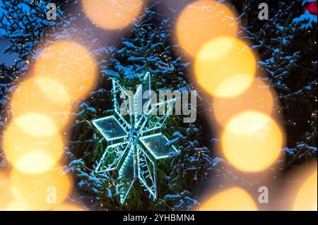Mit Weihnachtsbäumen bedeckter Schnee mit gelben Lichtern und Bokeh-Kopierraum Stockfoto