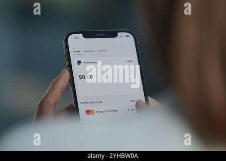 China. November 2024. In dieser Fotoabbildung durchsucht Eine Frau die Paypal-APP auf ihrem Smartphone, um eine Online-Zahlung zu tätigen. Stockfoto