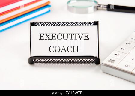 Geschäftskonzept. Der Satz, der Text, das Wort EXECUTIVE COACH stehen auf einer Visitenkarte in einem Stand auf weißem Hintergrund. Stockfoto