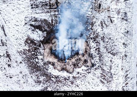 Brennender Dunghaufen auf dem Bauernhof, Luftverschmutzung und Verschmutzung, Luftaufnahme von Drohnen-pov, Hochwinkelansicht Stockfoto