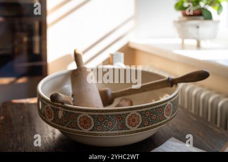 Eine altmodische Kücheneinrichtung. Vintage-Keramikschale mit Küchenutensilien. Set von alten Küchenutensilien, Retro-Ausrüstung von Großmutter. Stockfoto