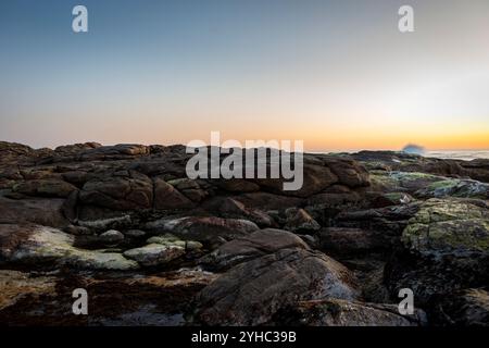 Eine felsige westaustralische Küstenlandschaft in der Abenddämmerung mit einem Himmel, der von Blau bis Orange reicht Stockfoto