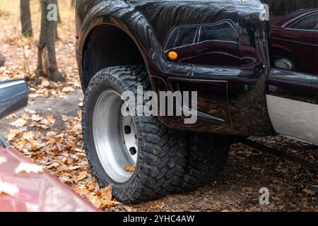 Nahaufnahme Detail unten pov Ansicht von Dual Twin Offroad Performance Rad von Super Heavy Duty Pickup LKW-Auto in Herbst Wald Landschaft Auffahrt Stockfoto