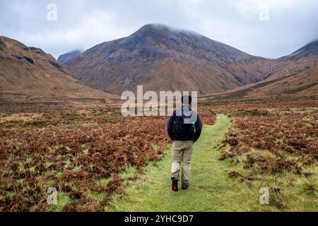 Ein junger Mann wandert durch die Cuillin Hiills/Mountains auf dem Sligachan zum Elgol Walk, Isle of Skye, Schottland, Großbritannien. Stockfoto