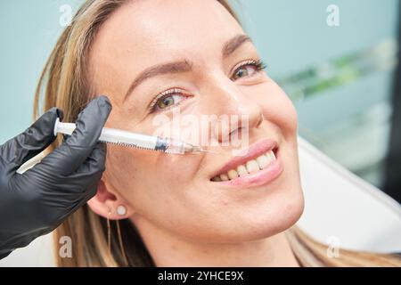 Eine Frau auf Einer Kosmetikbehandlung Eine Nahaufnahme einer schönen kaukasischen Frau, die eine kosmetische Behandlung hat und Falten füllt Stockfoto