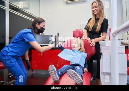 Zahnarzt-High-Five das Kind, das mit seiner Mutter zum Zahnarzt gekommen ist Stockfoto