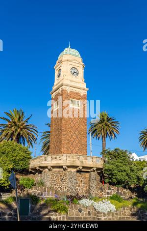 Carlo Catani Memorial Clock Tower of St. Kilda in der Nähe von Melbourne, umgeben von Palmen vor einem klaren blauen Himmel, Victoria, Australien Stockfoto