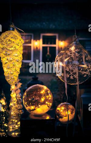 Beleuchtete Weihnachtsdekorationen mit warmen leuchtenden Lichtern, die an einem Winterabend in den Niederlanden im Freien ausgestellt werden. Stockfoto