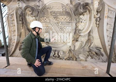 Dresden, Deutschland. November 2024. Der Restaurator Stephan Heisig inspiziert das sächsische Wappen auf dem renovierten Carillon-Pavillon im Dresdner Zwinger während einer Presserundfahrt auf einem Gerüst. Die Dresdner Zwingerbauhütte wurde vor 100 Jahren gegründet. Quelle: Sebastian Kahnert/dpa/Alamy Live News Stockfoto