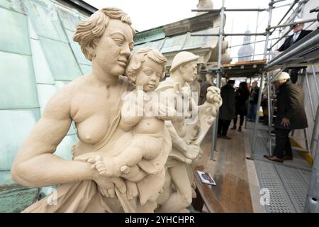 Dresden, Deutschland. November 2024. Die Teilnehmer einer Pressetour laufen auf Gerüsten hinter Sandsteinfiguren im renovierten Carillon-Pavillon im Dresdner Zwinger. Die Dresdner Zwingerbauhütte wurde vor 100 Jahren gegründet. Quelle: Sebastian Kahnert/dpa/Alamy Live News Stockfoto