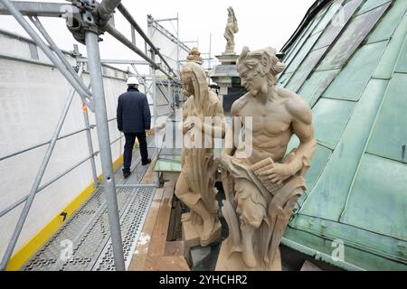 Dresden, Deutschland. November 2024. Die Teilnehmer einer Pressetour laufen auf Gerüsten hinter Sandsteinfiguren im renovierten Carillon-Pavillon im Dresdner Zwinger. Die Dresdner Zwingerbauhütte wurde vor 100 Jahren gegründet. Quelle: Sebastian Kahnert/dpa/Alamy Live News Stockfoto