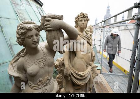 Dresden, Deutschland. November 2024. Die Teilnehmer einer Pressetour laufen auf Gerüsten hinter Sandsteinfiguren im renovierten Carillon-Pavillon im Dresdner Zwinger. Die Dresdner Zwingerbauhütte wurde vor 100 Jahren gegründet. Quelle: Sebastian Kahnert/dpa/Alamy Live News Stockfoto