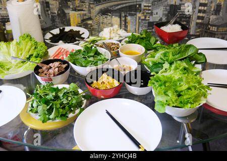 Frühlingsbrötchen mit Huhn oder Garnelen in Reispapier mit süß-saurer Sauce in Nahaufnahme, die traditionelle koreanische chinesische Küche kocht. Die Herstellung von Federrollen erfolgt Schritt für Schritt Stockfoto