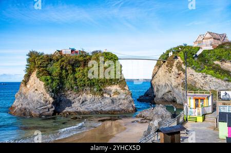 Eine Hängebrücke ermöglicht den Zugang zu „The Island“, einem Ferienhaus auf einem Felsvorsprung über Towan Beach in Newquay, Cornwall, England, Großbritannien. Stockfoto