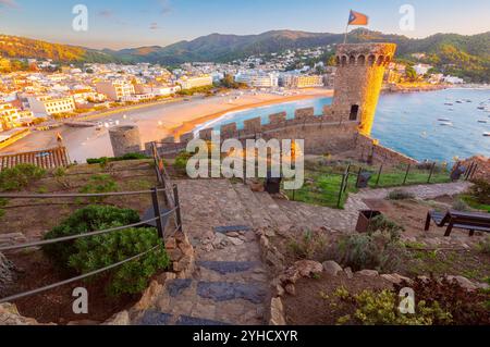 Steinturm mit katalanischer Flagge in alter Festung über der Bucht bei Sonnenaufgang, Tossa de Mar, Katalonien, Spanien Stockfoto