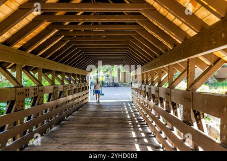 Vail, USA - 3. Juli 2022: Hölzerne überdachte Brücke in Colorado über den Fluss Gore Creek in Skigebiet Stadt an Lodge-Hotelgebäuden im Sommer mit Menschen Stockfoto