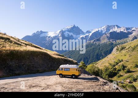 Retro-Wohnmobil im Wald mit hohen Bergen im Hintergrund, Ecrins-Nationalpark, Frankreich Stockfoto