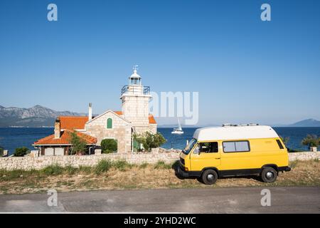 Gelber Retro-Wohnmobil parkt in der Nähe des Leuchtturms Sucuraj auf der Insel Hvar, Kroatien Stockfoto