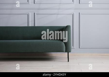 Komfortables Sofa in der Nähe einer grauen Wand im Zimmer Stockfoto