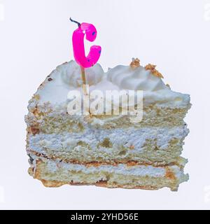 Urlaubskuchen. Ein Stück Biskuitkuchen mit erloschenen Kerzen in Form des Buchstaben C. Stockfoto