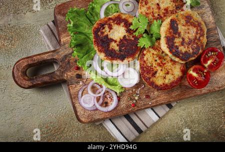 Gebratene Hähnchenkoteletts, gehacktes Huhn, mit Gemüse, auf einem Schneidebrett, mit Gemüsesalat, Blick von oben, hausgemacht, keine Leute Stockfoto