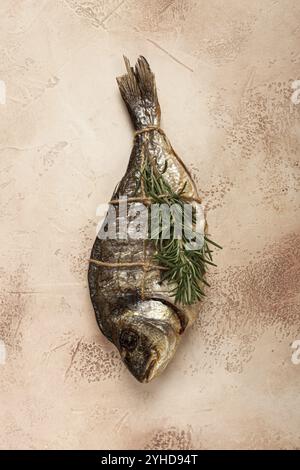 Heiß geräucherter dorado-Fisch, mit einem Zweig Rosmarin, mit einem Seil gebunden, auf dem Tisch, Blick von oben, geräucherter Fisch, Nahaufnahme, keine Personen Stockfoto