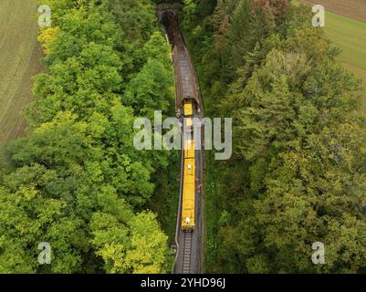 Aus der Vogelperspektive eines gelben Zuges, der durch einen Tunnel und einen Wald fährt, Stanzmaschine, Hermann Hessebahn, Althengstett, Schwarzwald, Deutschland, Europ Stockfoto