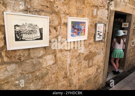 Ein Mädchen im Alter von 12 Jahren betritt einen Souvenirladen, in dem Souvenirs aus Zimmern innerhalb der Stadtmauer/Mauern der Altstadt von Dubrovnik, Kroatien, verkauft werden. (138) Stockfoto