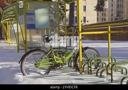 MOSKAU, RUSSLAND, 11. JANUAR 2017: Einsames Fahrrad den ganzen Winter über auf dem Fahrradparkplatz. Moskau, in der Nähe des Eingangs zum Hauptgebäude von Moscow S Stockfoto