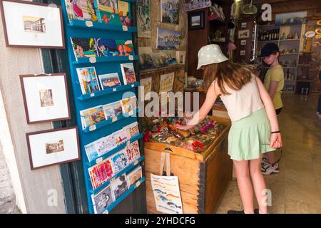 Kinder / Kinder / Mädchen, die Souvenirs aus Zimmern innerhalb der Stadtmauer kaufen; Altstadt von Dubrovnik, Kroatien. (138) Stockfoto