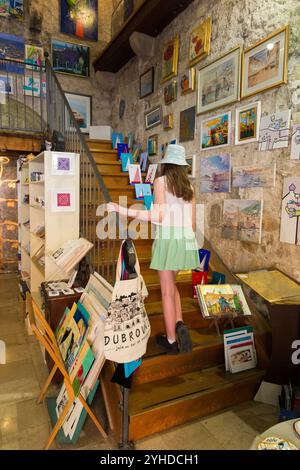 Kinder / Kinder / Mädchen, die Souvenirs aus Zimmern innerhalb der Stadtmauer kaufen; Altstadt von Dubrovnik, Kroatien. (138) Stockfoto