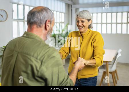 Romantisches und glückliches kaukasisches Seniorenpaar, das zusammen in einer gemütlichen Wohnung tanzt Stockfoto