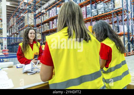 Drei weibliche Fabrikarbeiter verpacken Pakete für die Lieferung in ein Vertriebslager Stockfoto
