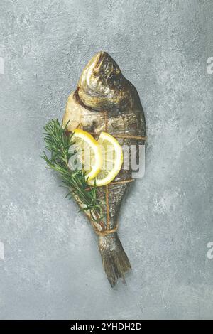 Heiß geräucherter dorado-Fisch, mit einem Zweig Rosmarin, mit einem Seil gebunden, auf dem Tisch, Blick von oben, geräucherter Fisch, Nahaufnahme, keine Personen Stockfoto