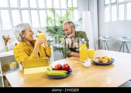 Glückliches Seniorenpaar genießt ein gesundes Frühstück im Wohnzimmer zu Hause Stockfoto