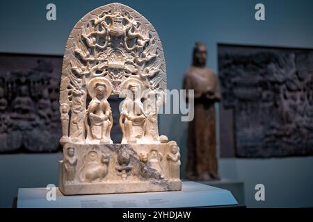 WASHINGTON DC, Vereinigte Staaten – Marmorstele, die Maitreya, Buddha der Zukunft, neben den Buddhas der Vergangenheit und Gegenwart darstellt, die 565 n. Chr. in Quyang, Provinz Hebei, China, geschaffen wurde. Diese bedeutende buddhistische Skulptur, die in der Freer Gallery of Art ausgestellt wird, veranschaulicht religiöse Kunst der Nördlichen Qi-Dynastie und raffinierte Steinschnitzertechniken. Stockfoto