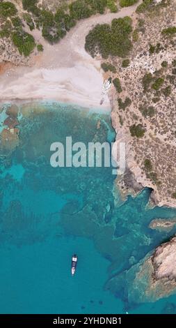Blick aus der Vogelperspektive auf die abgeschiedene mediterrane Bucht mit unberührtem Sandstrand, umgeben von zerklüfteter Küste und kristallklarem türkisfarbenem Wasser Stockfoto