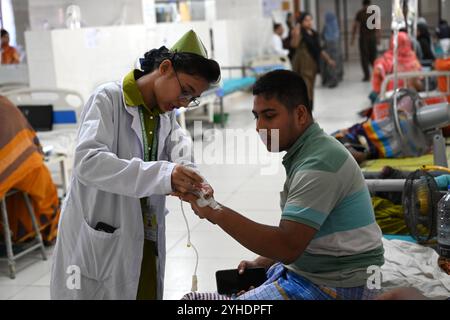 Dhaka, Bangladesch. November 2024. Krankenschwester behandelt einen Patienten, der mit Moskitonetzen bedeckt ist und an Dengue-Fieber leidet, ruhen Sie sich am 11. November 2024 im „Shaheed Suhrawardy“ Medical College Hospital in Dhaka, Bangladesch. Seit dem 1. Januar 2024 bis zum 11. November 2024 sind insgesamt 75.142 Menschen von Dengue betroffen. Mindestens 310 Menschen sind bei Bangladeschs schlimmstem Dengue-Ausbruch aller Zeiten gestorben, sagten Beamte am 11. November, als überlastete Krankenhäuser kämpfen, Tausende von Patienten zu behandeln. Quelle: Mamunur Rashid/Alamy Live News Stockfoto