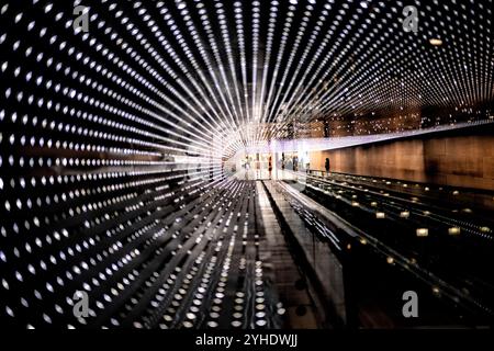 WASHINGTON DC, USA – „Multiverse“, die LED-Lichtinstallation von Leo Villareal aus dem Jahr 2008, beleuchtet den Verbindungsweg zwischen den Gebäuden East und West der National Gallery of Art. Dieses beeindruckende Kunstwerk besteht aus Tausenden von LED-Leuchten, die durch Computerprogrammierung ständig wechselnde Muster erzeugen. Die Installation verwandelt den unterirdischen Durchgang in eine dynamische Lichtumgebung. Stockfoto