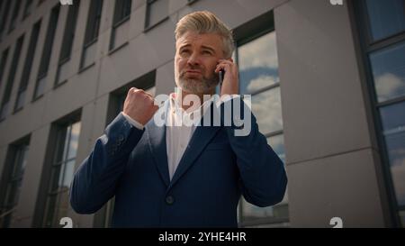 Seriöser älterer kaukasischer Geschäftsmann Firma CEO Berater Angestellter reifer männlicher Geschäftsmann Arbeitgeber sprechen Handy-Anruf in der Stadt Stockfoto