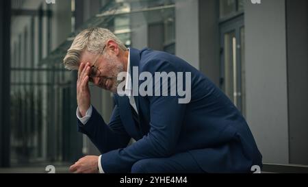 Kaukasischer alter Senior Geschäftsmann fühlt sich schlecht unwohl verärgert reifer Geschäftsmann betonte Stress mittleren Alters Verzweiflung Arbeitgeber in der Stadt im Freien Gefühl Stockfoto