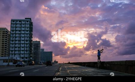 Ein Mann wirft seine Angelrute auf die Avenida Malecón. Sonnenuntergang in Havanna, Kuba Stockfoto