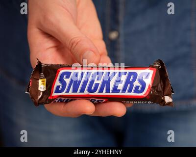 Tambow, Russische Föderation - 23. Januar 2024 Frau, die Snickers-Bar in der Hand hält. Nahaufnahme Stockfoto