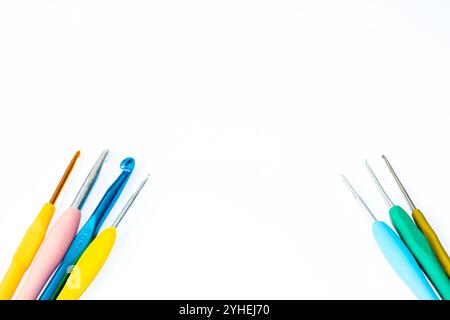 Helle Häkelhaken verschiedener Größe isoliert auf weißem Hintergrund. Kopierbereich, Draufsicht, flache Ladefläche. Konzept der Strickidee. Bunte Häkelhaken. Stockfoto