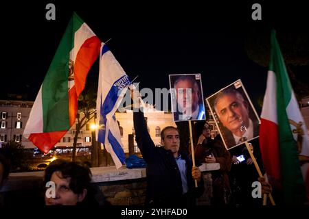 Rom, Rm, Italien. November 2024. Hunderte nehmen an der von der Jüdischen Gemeinde Roms organisierten Kundgebung gegen den Antisemitismus Teil. Die Rallye ist eine Reaktion auf die Auseinandersetzungen, die letzte Woche in Amsterdam nach dem Fußballspiel zwischen Ajax und Maccabi stattfanden. Ein Teilnehmer zeigt das Foto von Reza Pahlavi, dem letzten Kronprinzen des Iran, mit der Flagge Israels und der ehemaligen Flagge Irans. Quelle: ZUMA Press, Inc./Alamy Live News Stockfoto