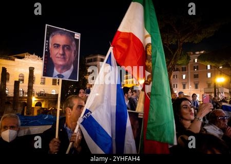 Rom, Rm, Italien. November 2024. Hunderte nehmen an der von der Jüdischen Gemeinde Roms organisierten Kundgebung gegen den Antisemitismus Teil. Die Rallye ist eine Reaktion auf die Auseinandersetzungen, die letzte Woche in Amsterdam nach dem Fußballspiel zwischen Ajax und Maccabi stattfanden. Ein Teilnehmer zeigt das Foto von Reza Pahlavi, dem letzten Kronprinzen des Iran, mit der Flagge Israels und der ehemaligen Flagge Irans. Quelle: ZUMA Press, Inc./Alamy Live News Stockfoto