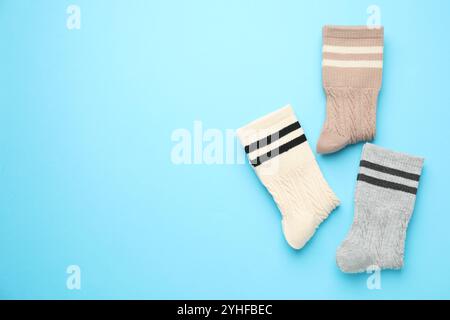 Verschiedene bequeme Socken auf hellblauem Hintergrund, flach geschnitten. Leerzeichen für Text Stockfoto