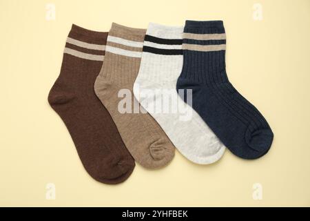 Verschiedene bequeme Socken auf beigefarbenem Hintergrund, flach geschnitten Stockfoto