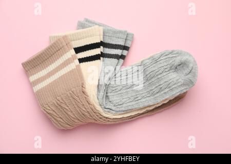 Verschiedene bequeme Socken auf hellrosa Hintergrund, Draufsicht Stockfoto