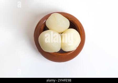 Blick von oben auf indische süße Rasgulla, in einem Tontopf, wunderschön präsentiert vor einem sauberen weißen Hintergrund. Indische Küche. Stockfoto